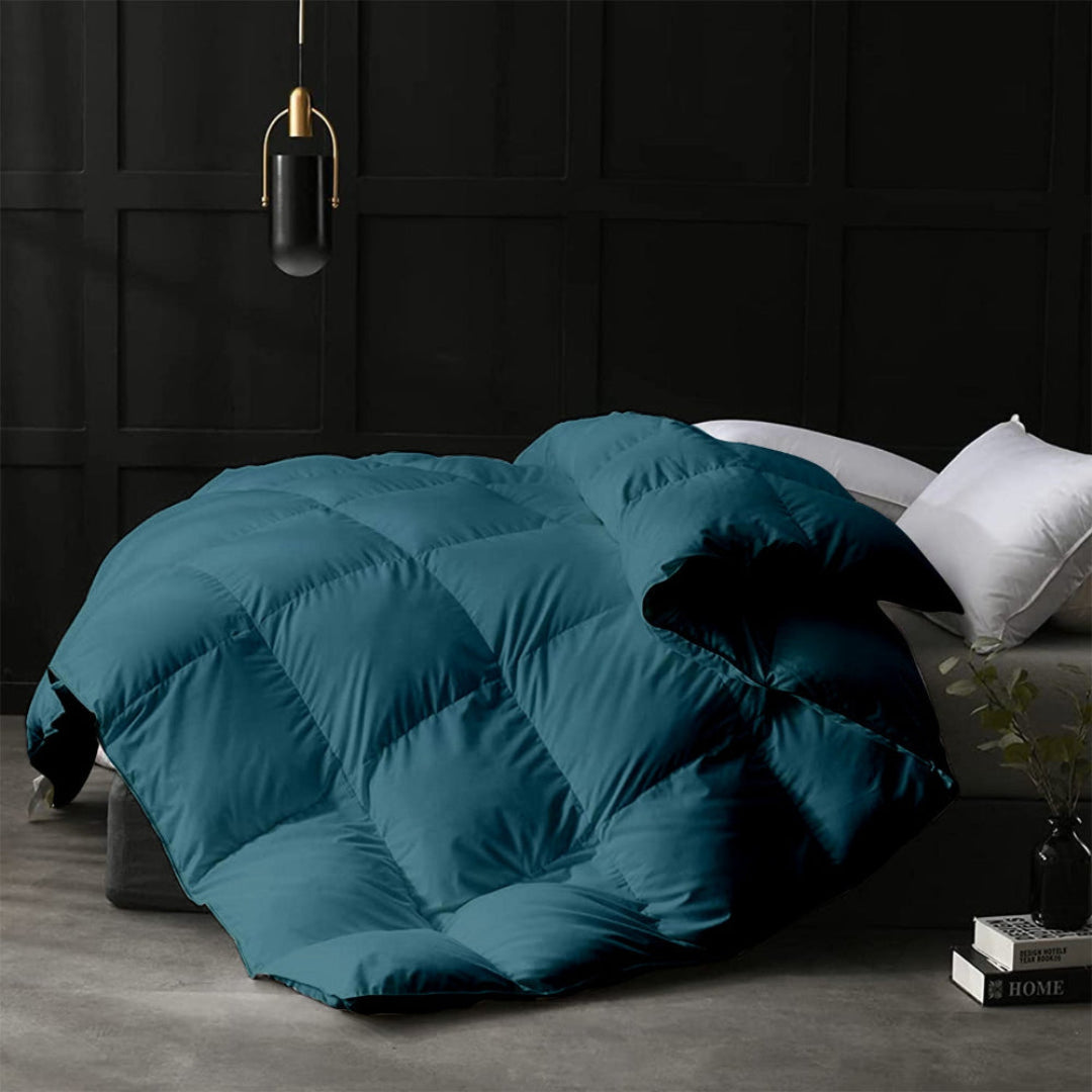 Teal comforter on a bed in a darkly decorated room.